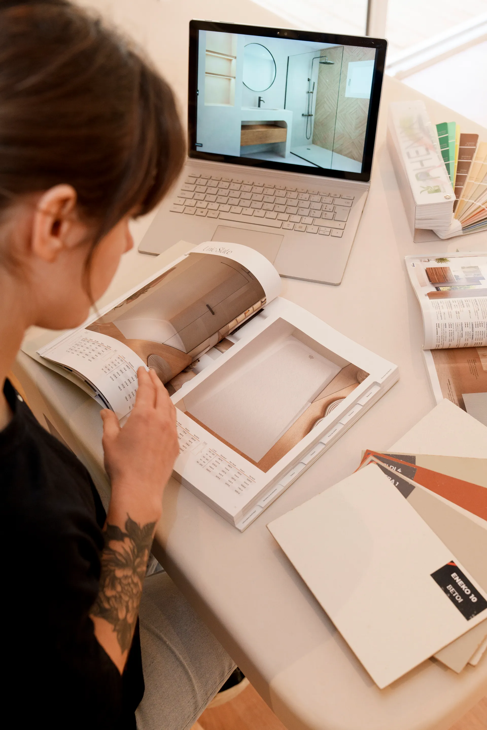 Juliette DOD& vue de dessus avec laptop, catalogues et échantillons béton ciré — phase de conception