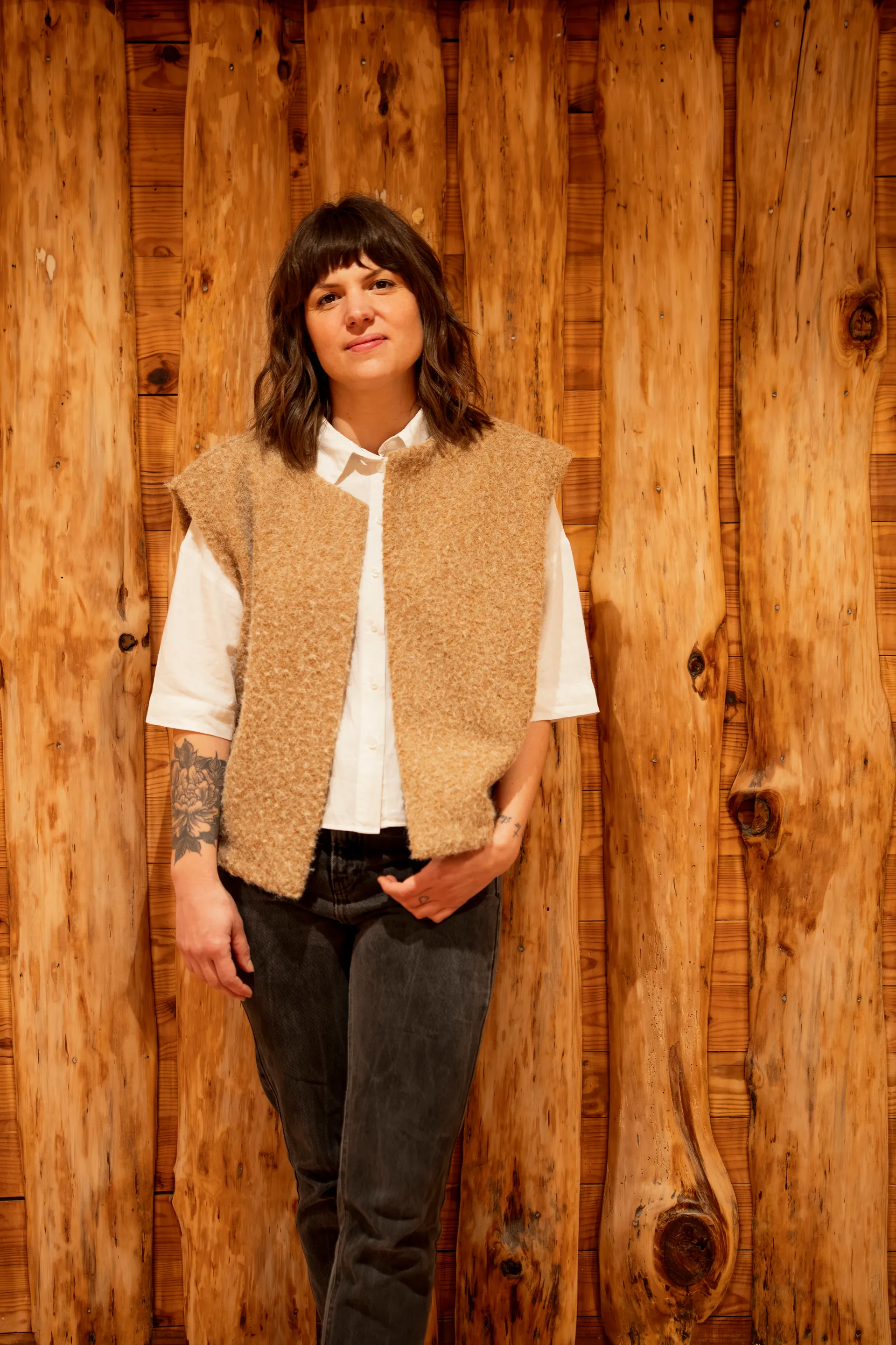 Juliette, co-fondatrice DOD& Béton Ciré — portrait debout devant fond bois